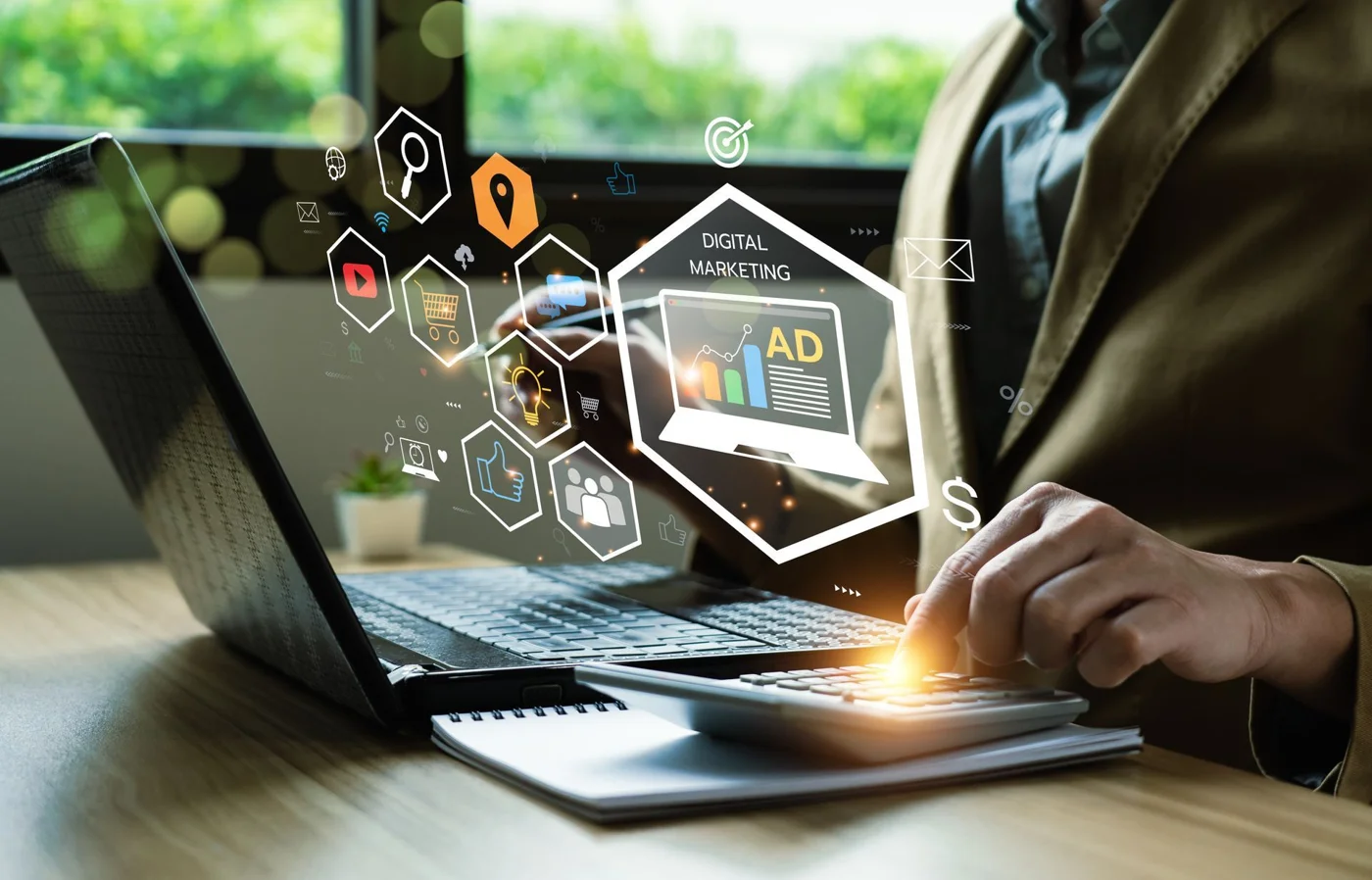 Person using laptop with digital marketing icons and ad analytics displayed holographically above keyboard