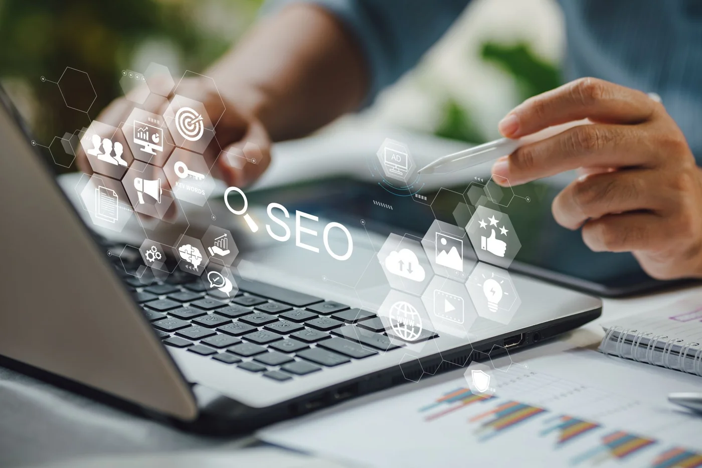 Person using laptop with SEO and digital marketing icons displayed on screen