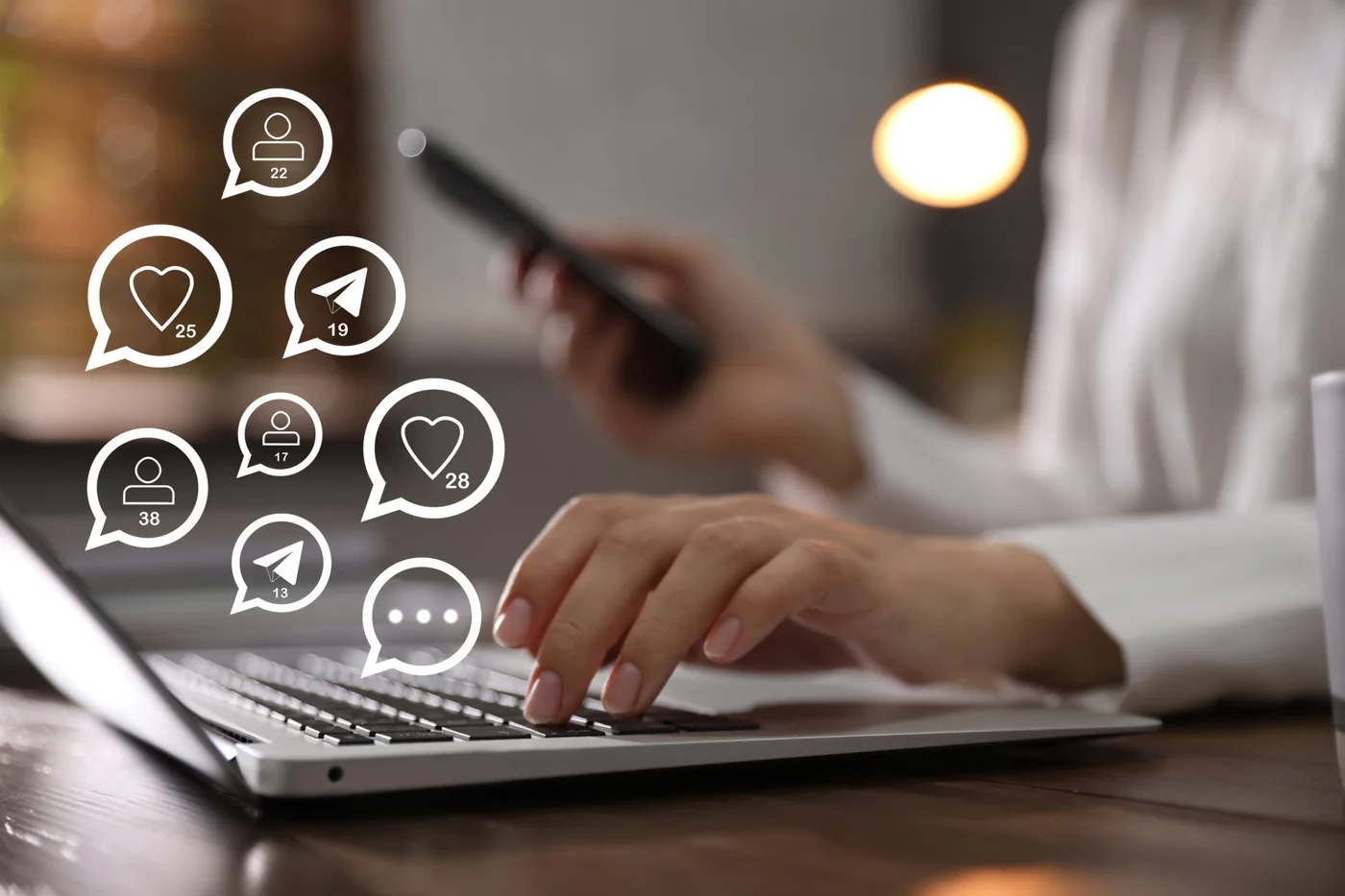 Person typing on laptop with social media engagement icons displaying likes, comments, and shares